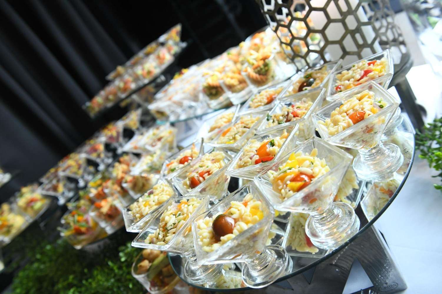 A tiered display of individually plated salads at a Colbeh event