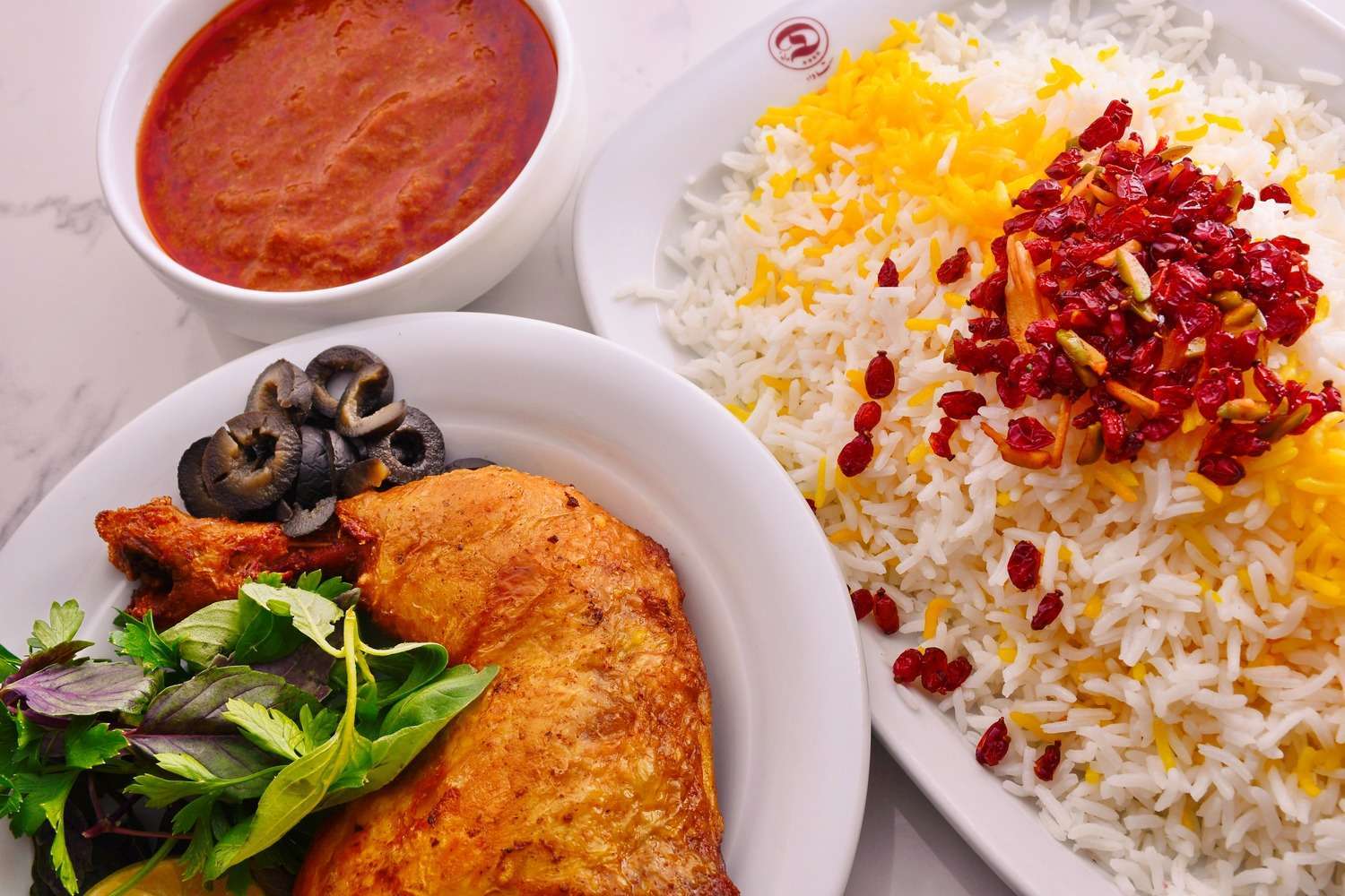 Saffron rice with barberries and roast chicken on branded Colbeh plates