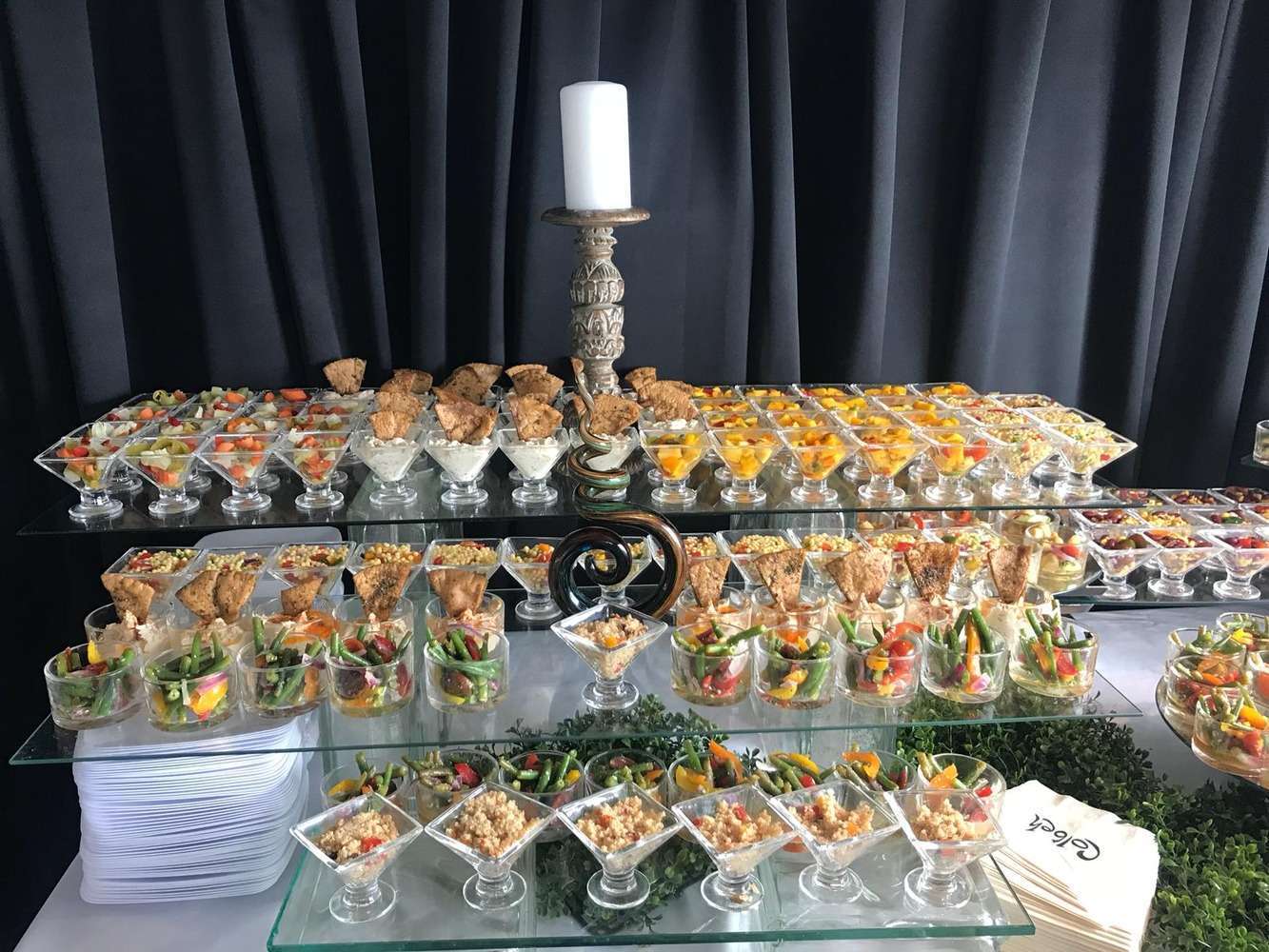 A Colbeh mezze display in glassware, tiered over mirrored trays